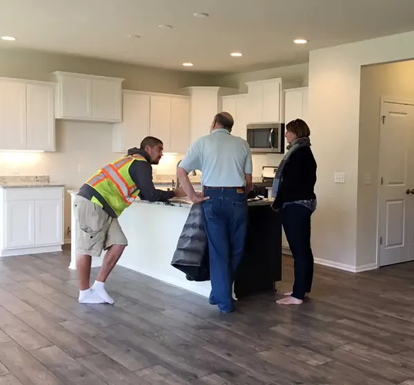 Owner Mike Keels walking homeowners through a finished white kitchen, Austin area